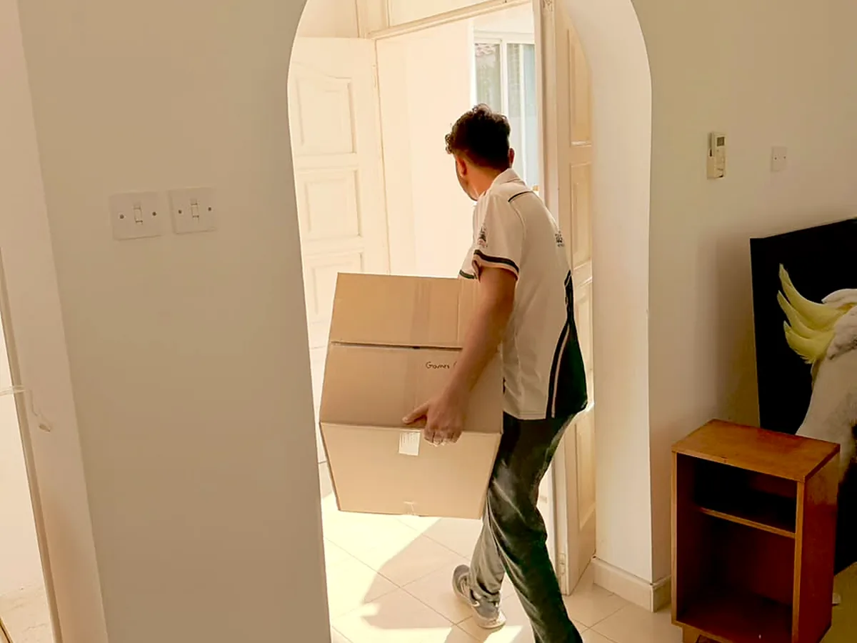 GulfNest mover carrying packed cartons during a residential move
